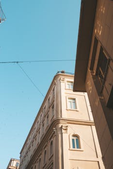 在晴朗的天空下，城市景观中阳光明媚的建筑立面，展示着经典的设计