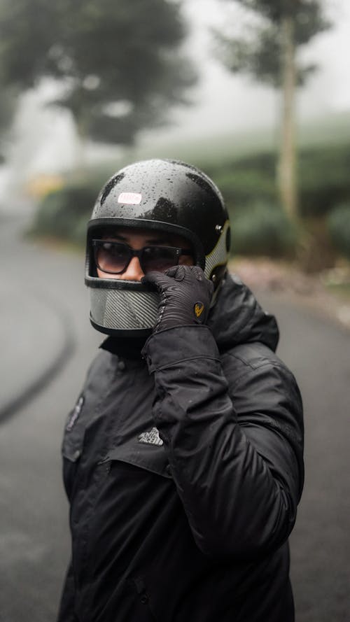 A man in a helmet and jacket talking on a cell phone