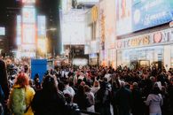 A bustling evening in Times Square with bright lights and a large crowd capturing the urban energy.