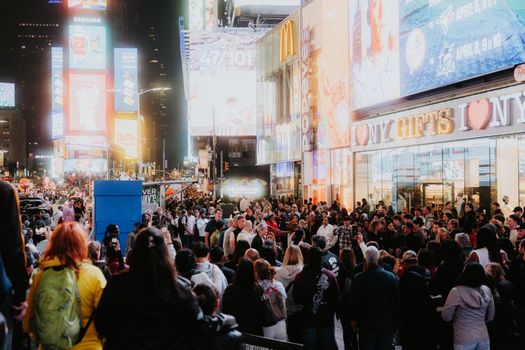 A bustling evening in Times Square with bright lights and a large crowd capturing the urban energy.