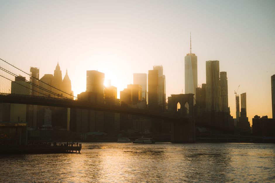 Stunning sunset over the Brooklyn Bridge and New York City skyline, showcasing modern architecture and urban life.