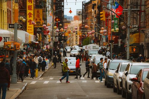 Free Lively urban scene in Chinatown with people walking and cars lining the street. Stock Photo