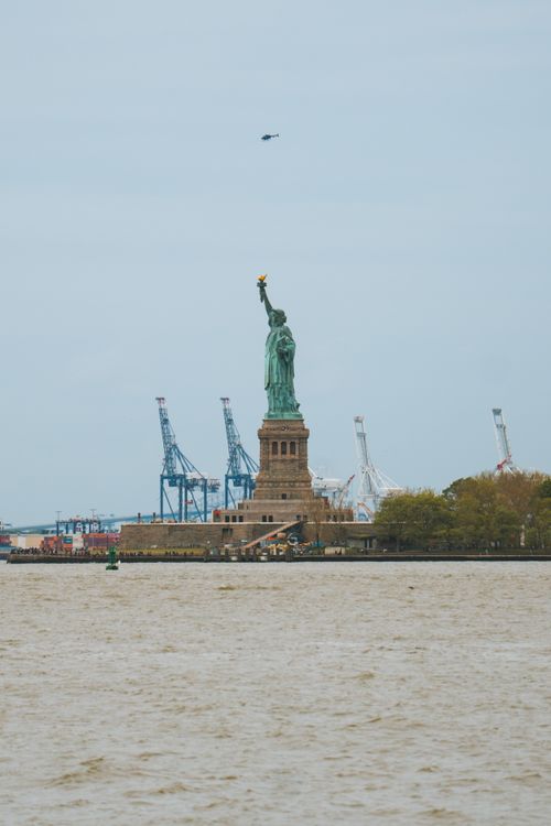 Free Iconic Statue of Liberty view across New York Harbor, perfect for travel and city themes. Stock Photo