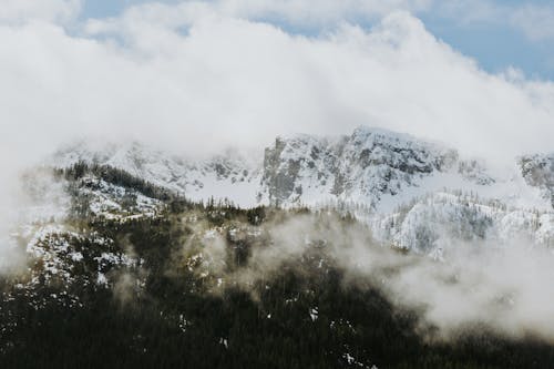 A mountain covered in snow and clouds