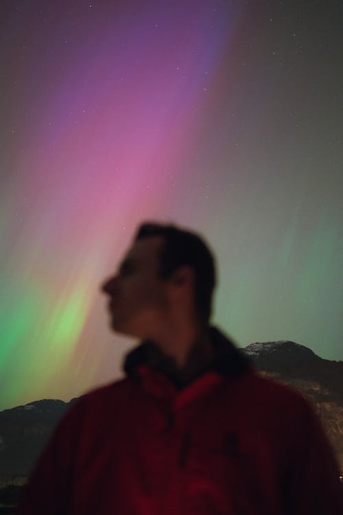 Blurred Man against Aurora Borealis