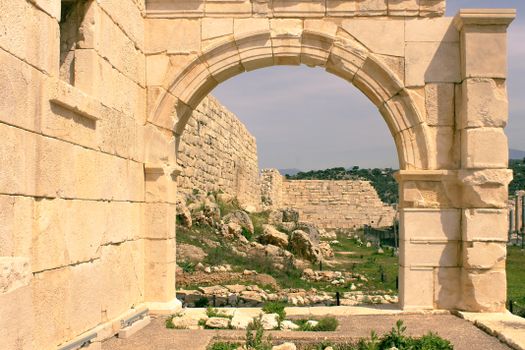 Wide stone archway in ancient ruins showcasing historical architecture.