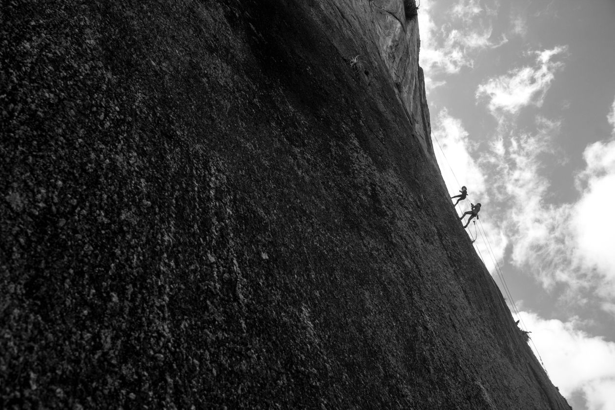 Climbers scaling a steep rock face