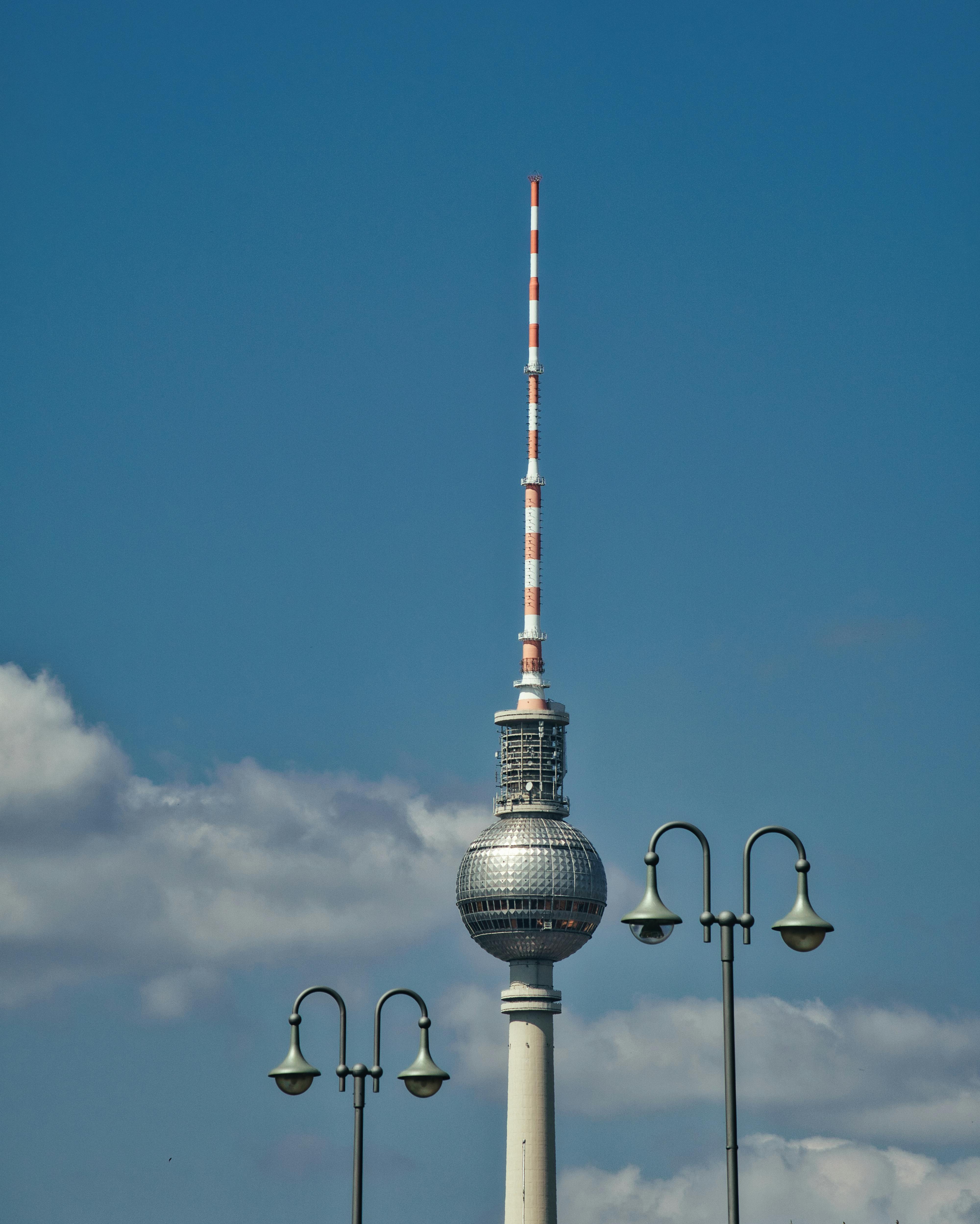 The Berlin Fernsehturm rises against a vibrant blue sky, showcasing its modern architecture and landmark status.