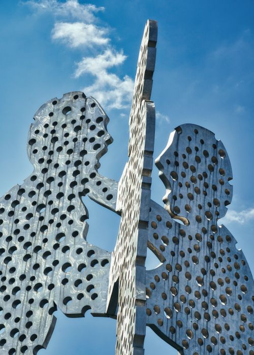 Free Captured in Berlin, the Molecule Man sculpture with a striking perforated design set against a vivid blue sky. Stock Photo