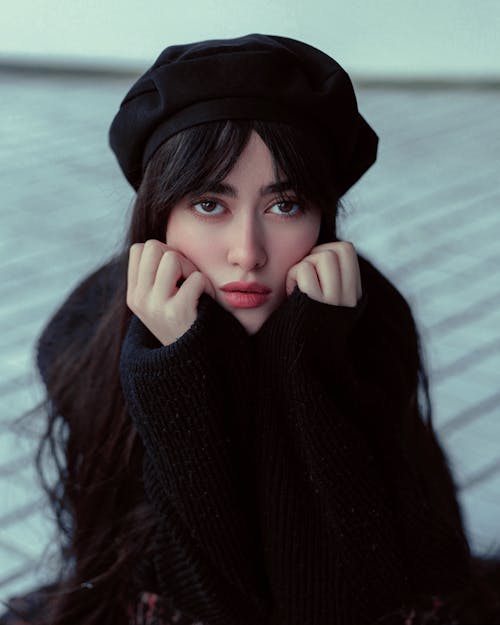 A woman with a black beret and black sweater