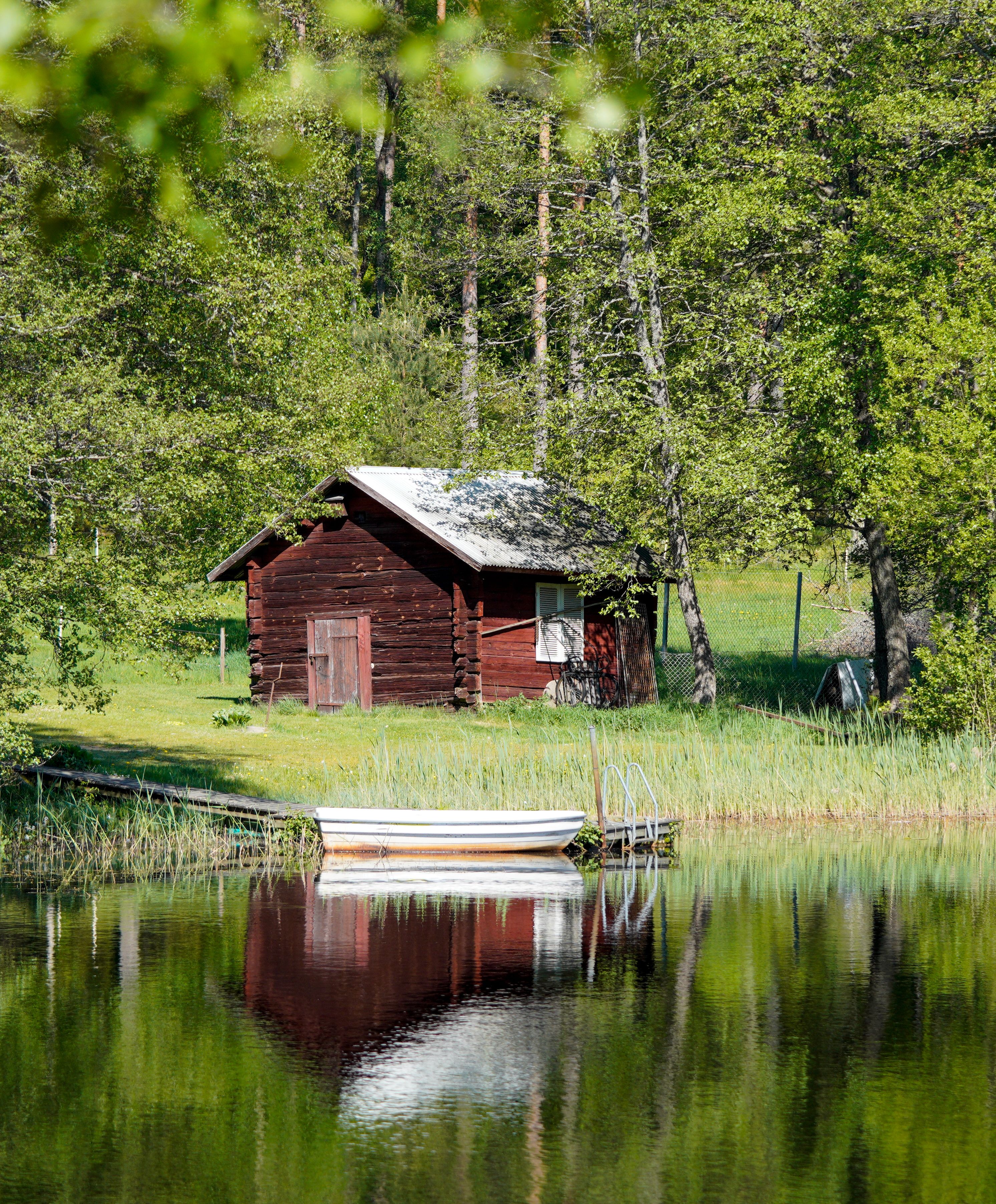 A small cabin sits on the shore of a lake · Free Stock Photo