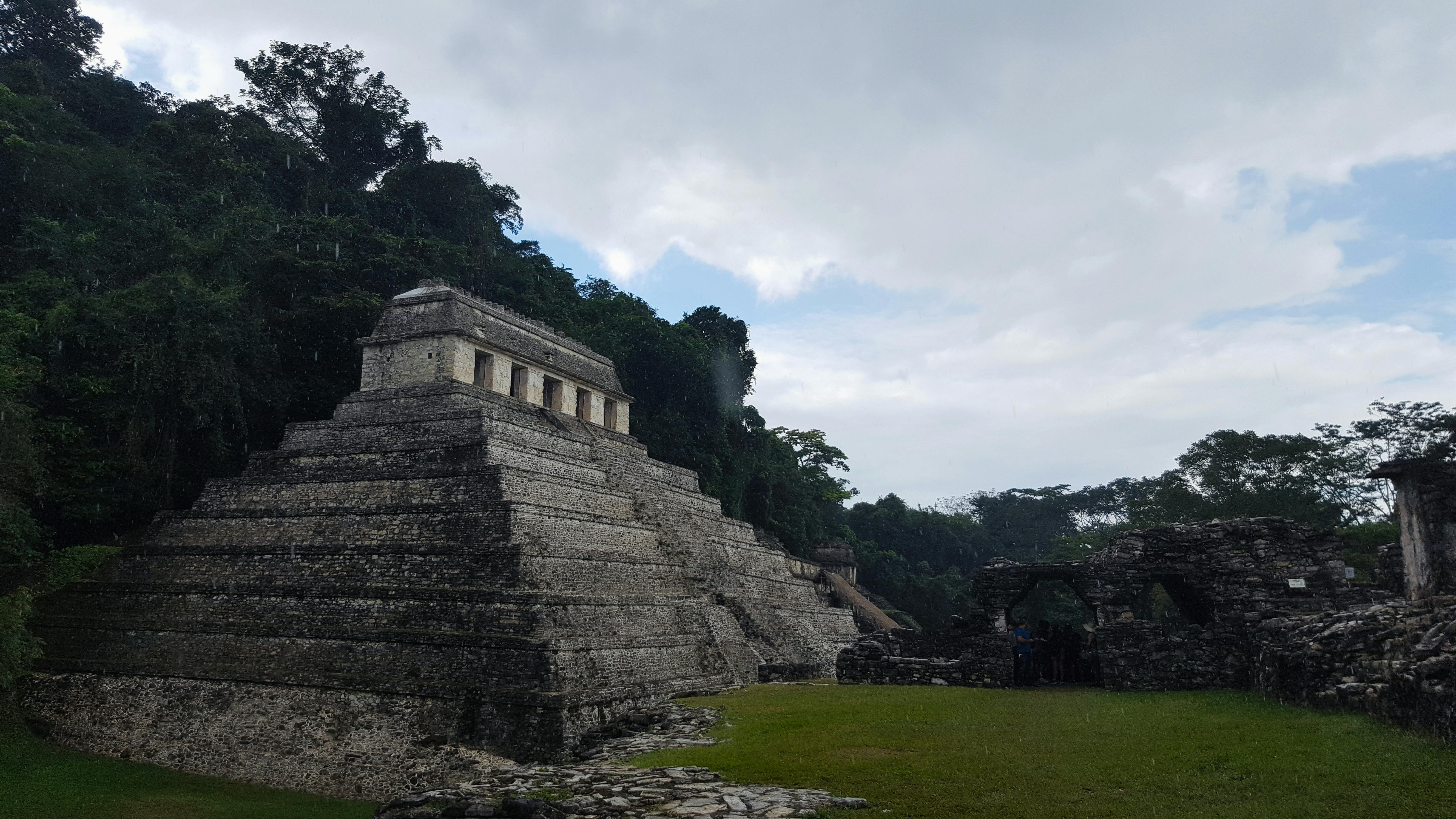 best time of year to visit mayan ruins - View of the historic Temple of the Inscriptions amidst lush jungle in Palenque, Chiapas.