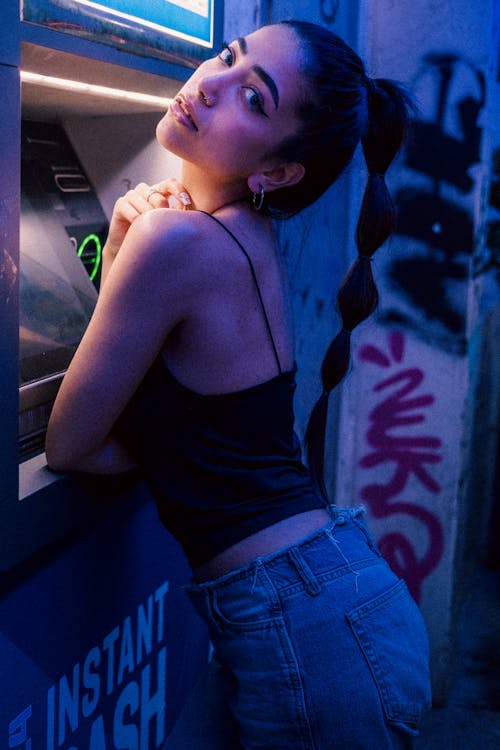 A woman leaning against a wall with a blue light