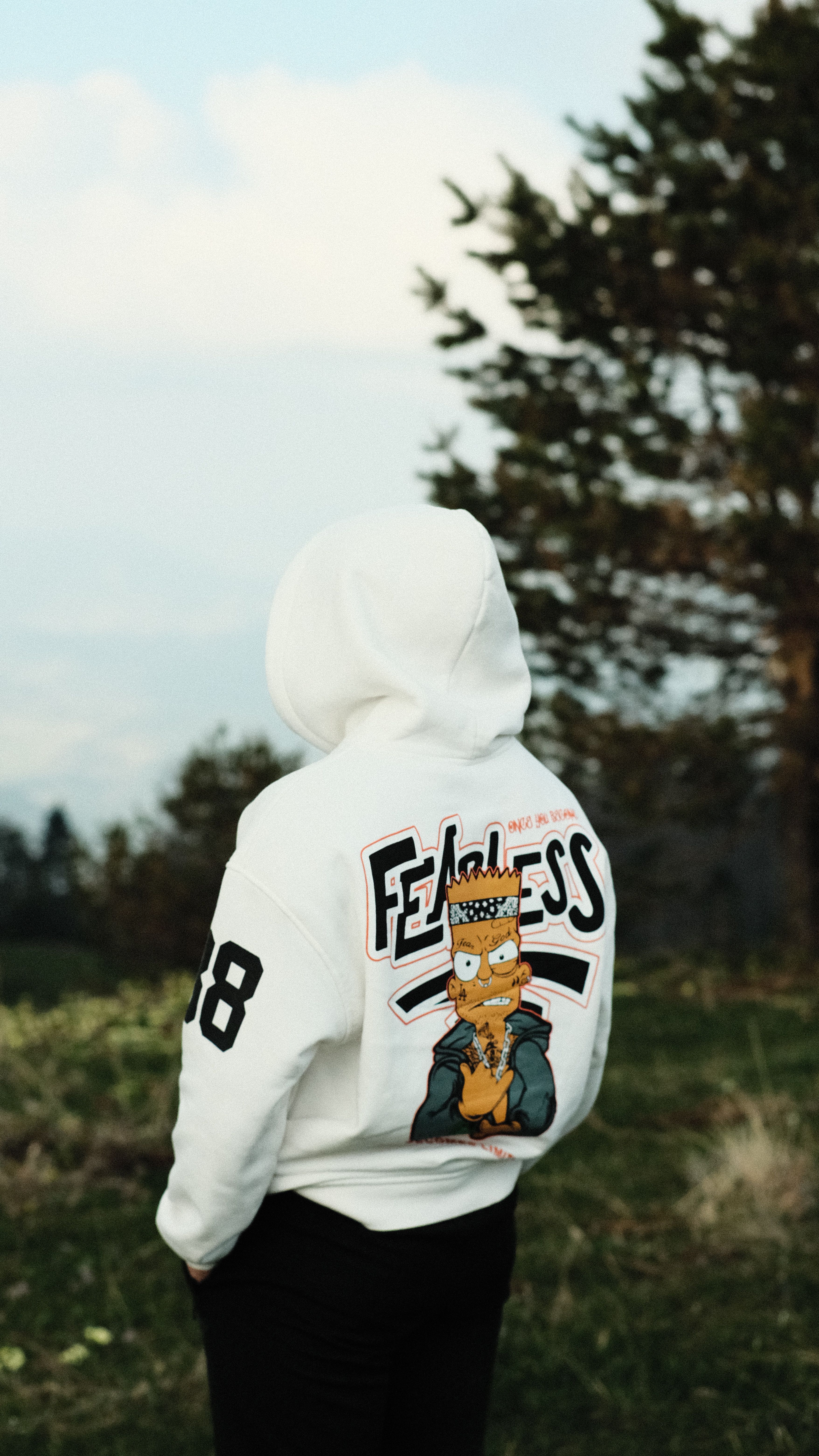 Person in a printed hoodie stands against a rural Zonguldak backdrop.