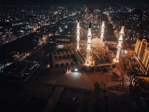 Vista Nocturna De La Mezquita Iluminada Con Las Luces De La Ciudad Circundante.