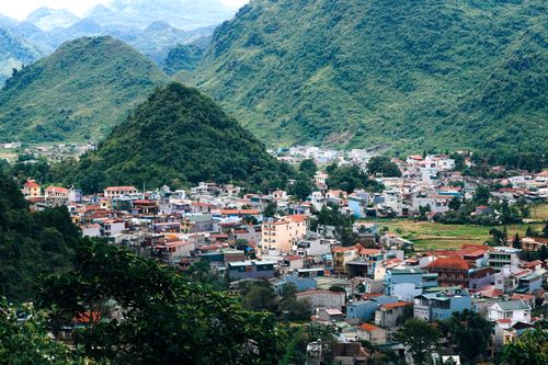 Free Charming town nestled in a valley surrounded by lush green hills, capturing a picturesque landscape. Stock Photo