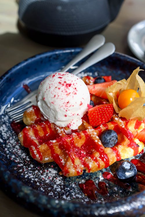 A blue plate topped with waffles and ice cream