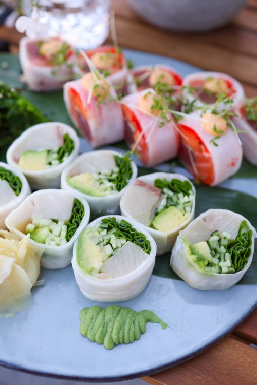 Free Mouth-watering sushi platter featuring fresh sashimi rolls with avocado and greens. Stock Photo