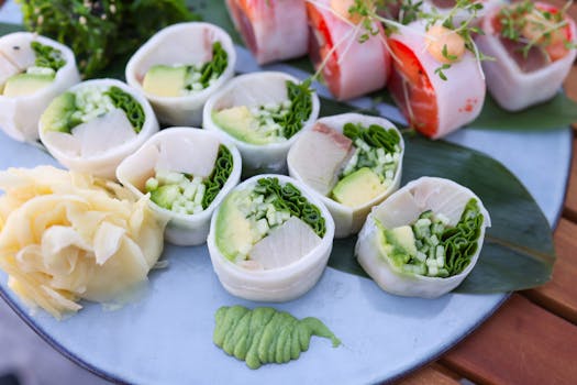 A vibrant plate of Japanese sushi rolls with avocado, cucumber, and ginger, showcasing fresh ingredients.