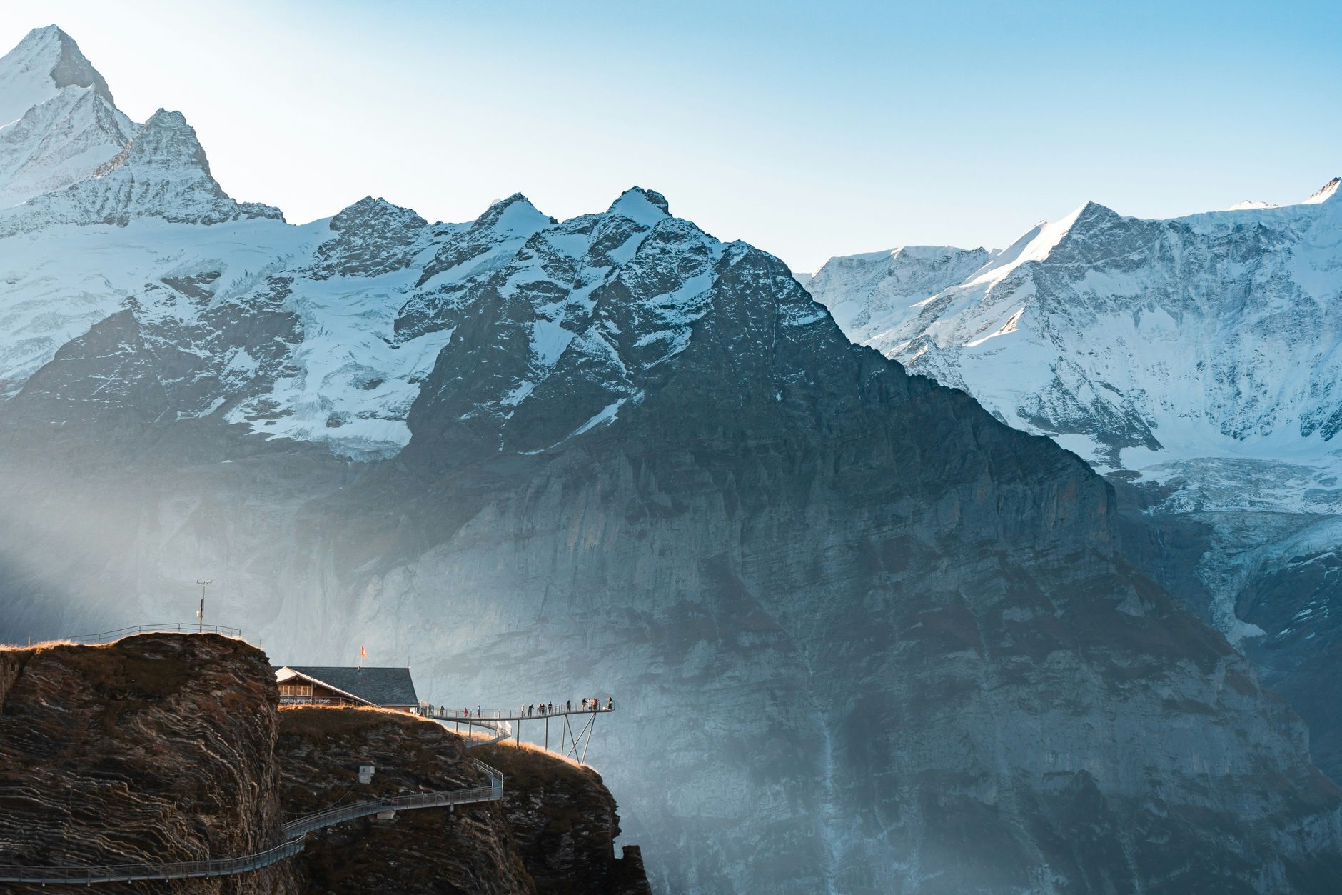 Explore the stunning snowcapped peaks and scenic walkways of the Swiss Alps at sunrise.