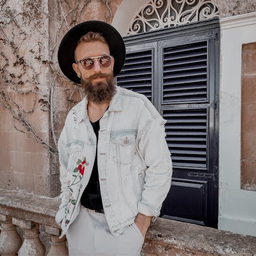 Man in Faded Denim Jacket Standing in Front of House