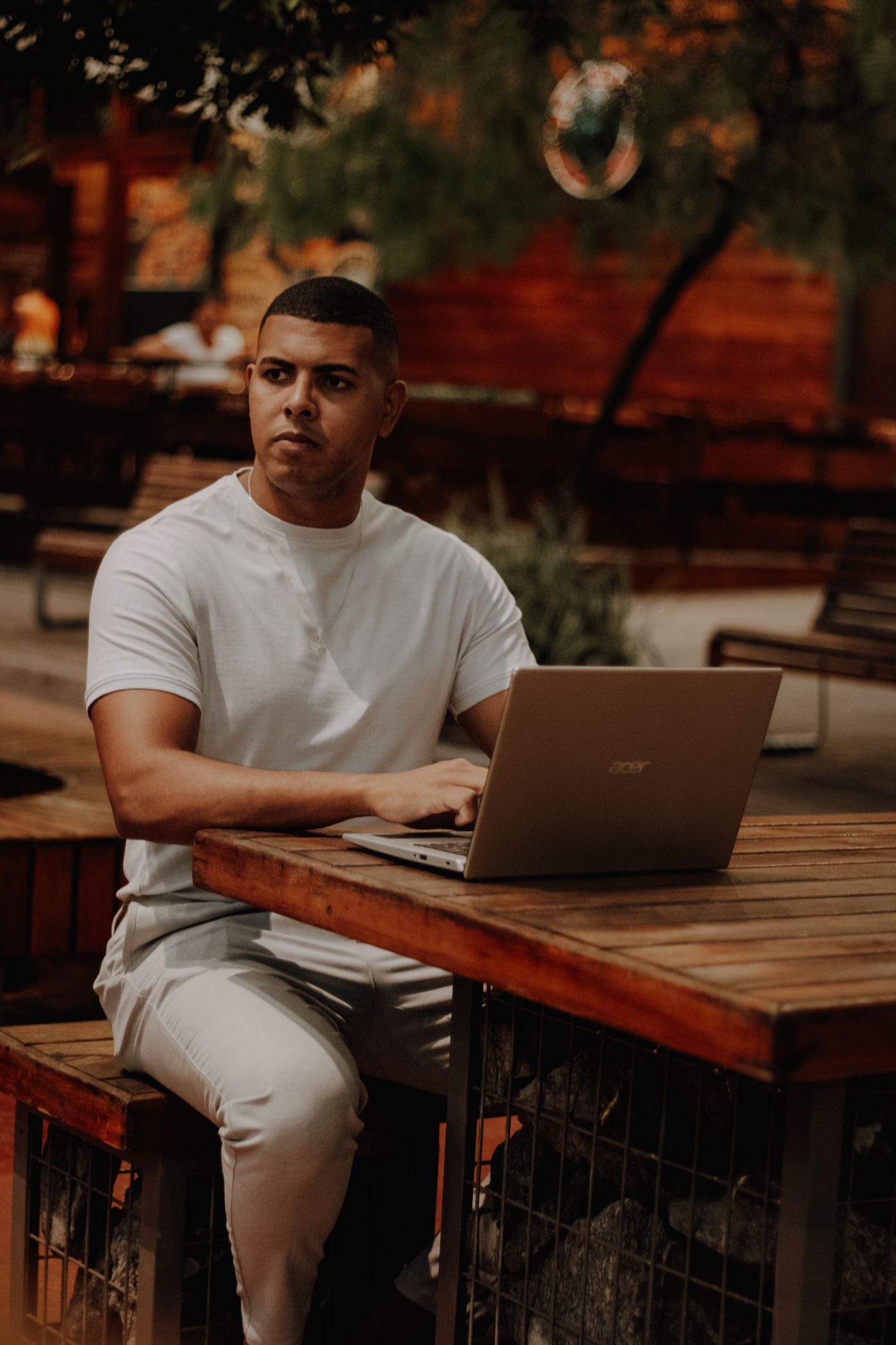 A person working on a laptop at an outdoor café table