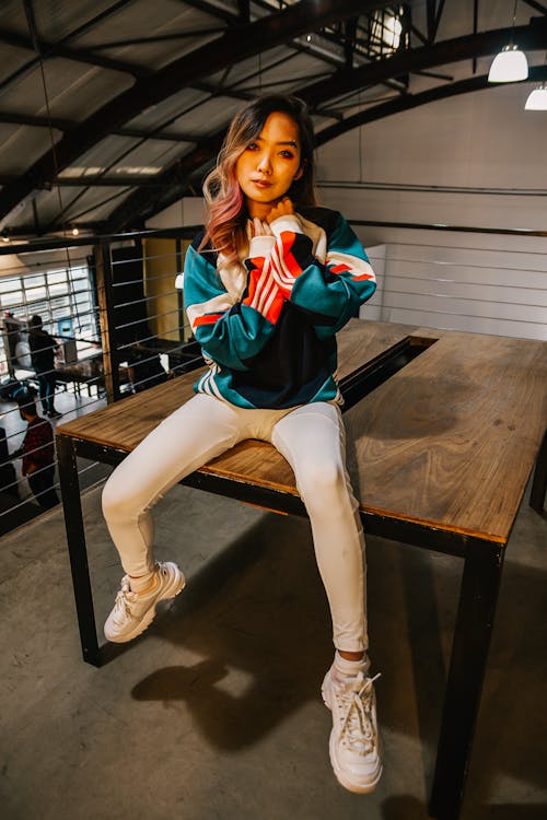 Free Woman Sitting on Brown Wooden Table Stock Photo