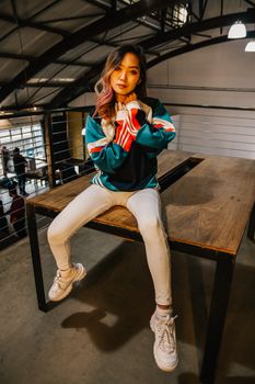 一位身着都市休闲服的少妇，自信地坐在室内，她的时尚画像栩栩如生