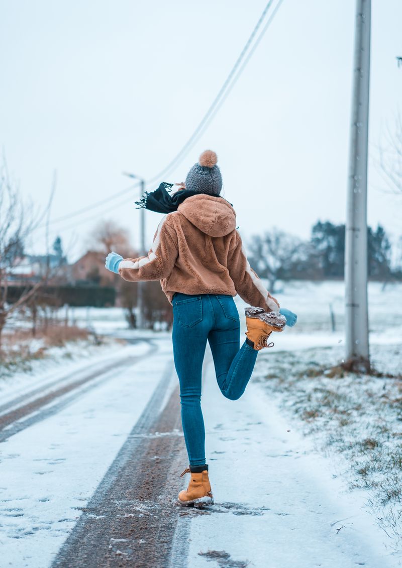 Woman in jeans and hooded jacket, snowy day