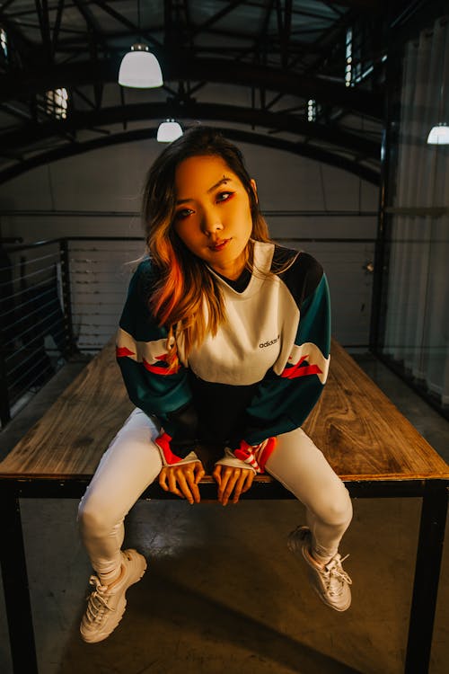 Woman Sitting on Top of a Wooden Table