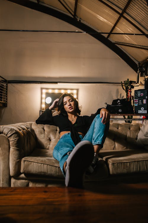 Free Woman Sitting on Brown Sofa Stock Photo