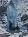 在挪威的冬季景观中，一个人拥抱冰冻瀑布的冰冷宏伟