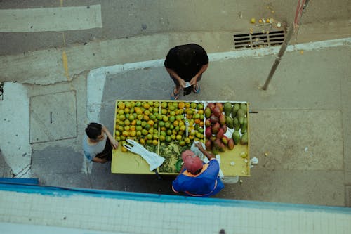 A man is standing next to a table with fruit