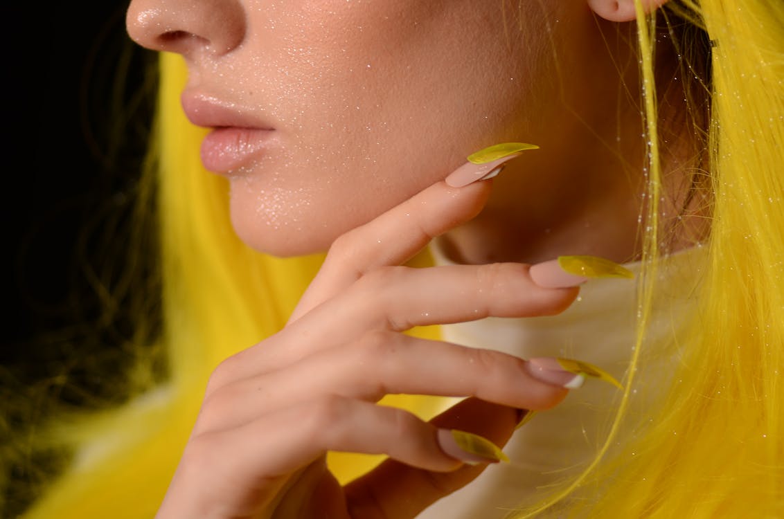 Free Close-up Photo of Woman With Yellow, Glitter on Her Face, and Yellow Nails Stock Photo