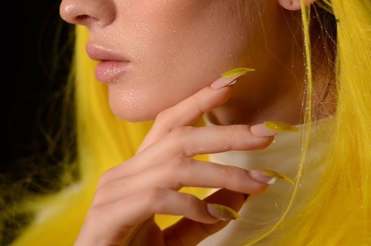 Close-up Photo Of Woman With Yellow, Glitter On Her Face, And Yellow Nails