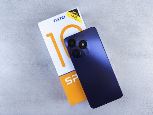 Free Blue smartphone on gray background. Featuring 128GB storage, displayed with its packaging. Modern technology focus. Stock Photo