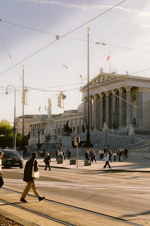 People walking across the street in front of a building