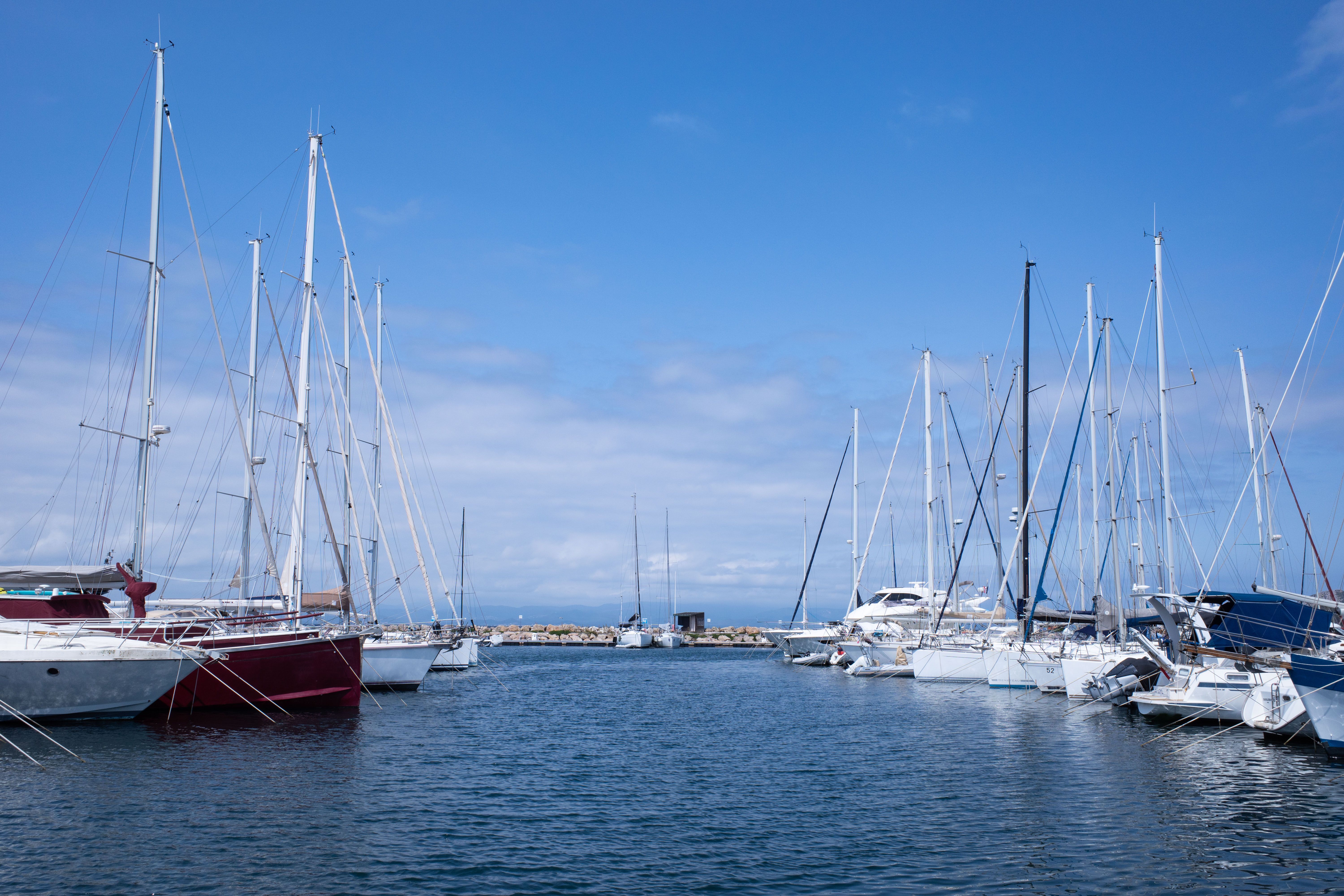 Motor yachts and boats moored in a calm marina under a clear summer sky, where Hawaii salt water works on every hull