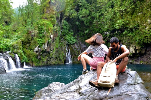 Foto Delle Coppie Che Si Siedono Sul Masso Vicino Al Lago