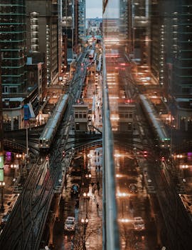 芝加哥的夜间城市景观充满活力，以火车、摩天大楼和倒影为特色