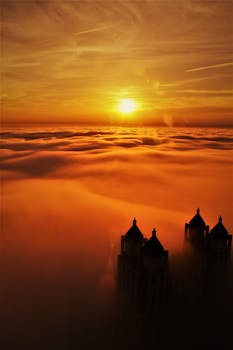 雾蒙蒙的城市景观被令人惊叹的日出照亮，塔楼的轮廓也随之显现