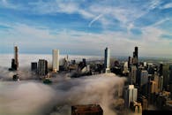 薄雾笼罩着城市地平线，现代摩天大楼和多云的天空在令人惊叹的鸟瞰图中展现