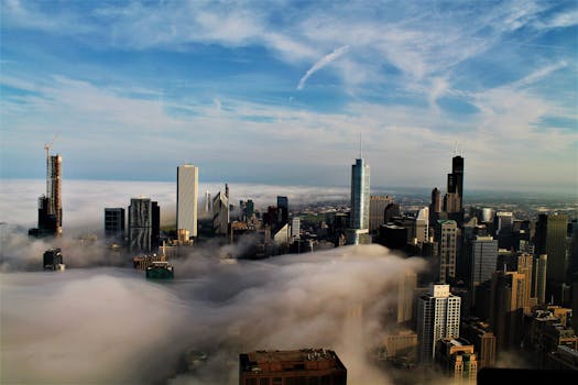 薄雾笼罩着城市地平线，现代摩天大楼和多云的天空在令人惊叹的鸟瞰图中展现