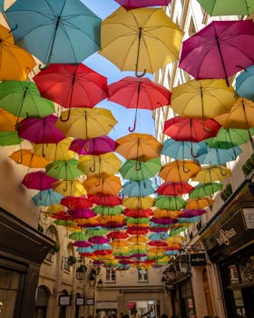 Vibrant umbrella display suspended above a picturesque Parisian street, creating a colorful canopy.
