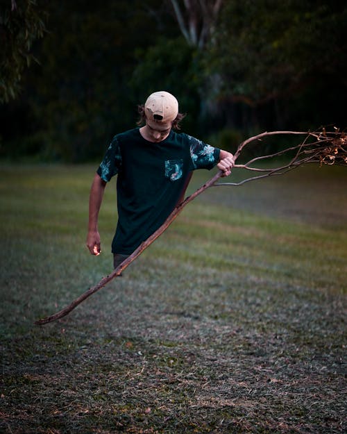 Man Holding Leafless Tree Branch