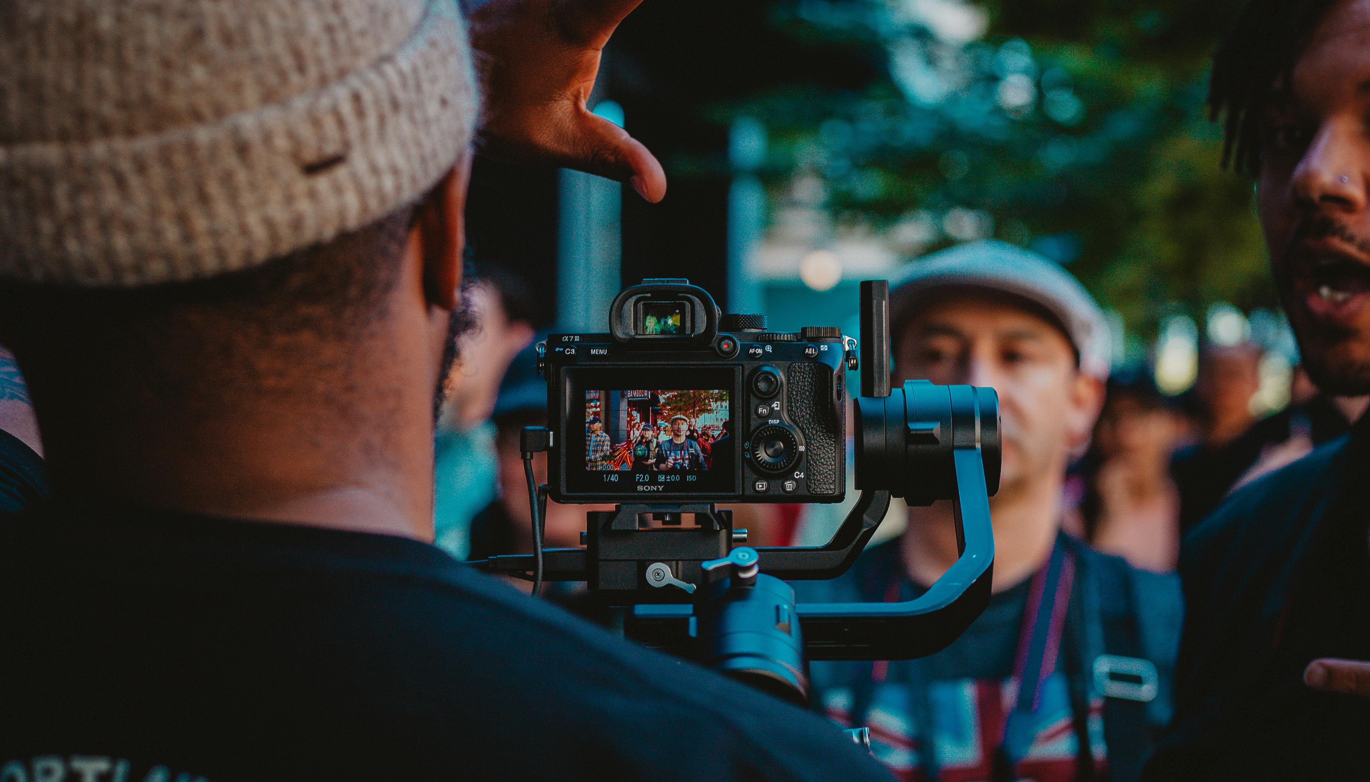 man operating camera in front of people