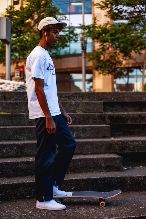 Man Standing Beside Stairs With Left Foot On Skateboard