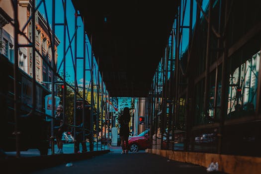 街景映在脚手架的玻璃倒影中，展现着城市生活