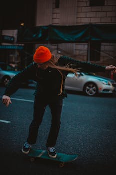 滑冰者头戴鲜艳的橙色无檐帽，在城市街道上表演特技