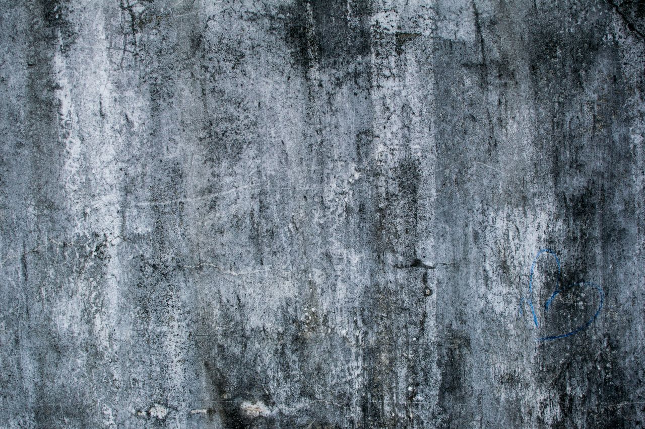 rough concrete wall texture with faint graffiti heart shape ideal for